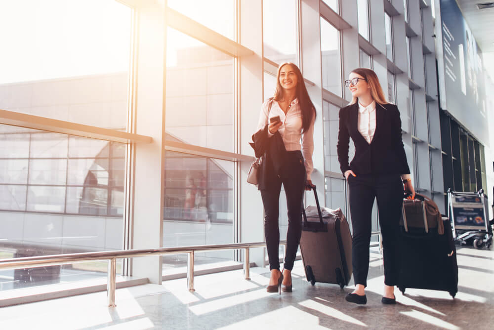 Two business partners walking through an airport, covered by annual travel insurance