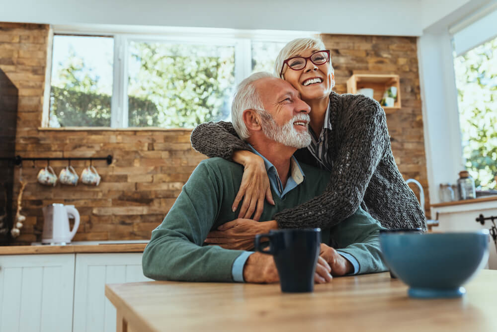 Older couple embracing in kitchen