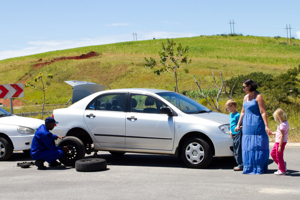 Mum and two kids wait while roadside assistance fixes their car