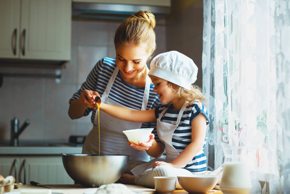 a mother and daughter baking in the kitchen