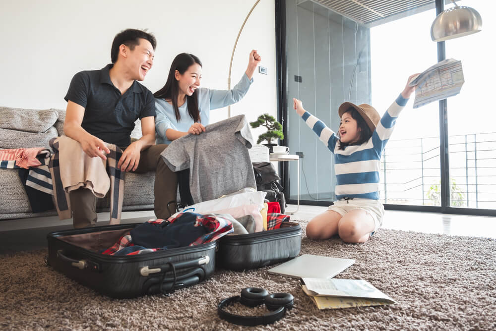 family packing luggage for an overseas holiday covered by family travel insurance