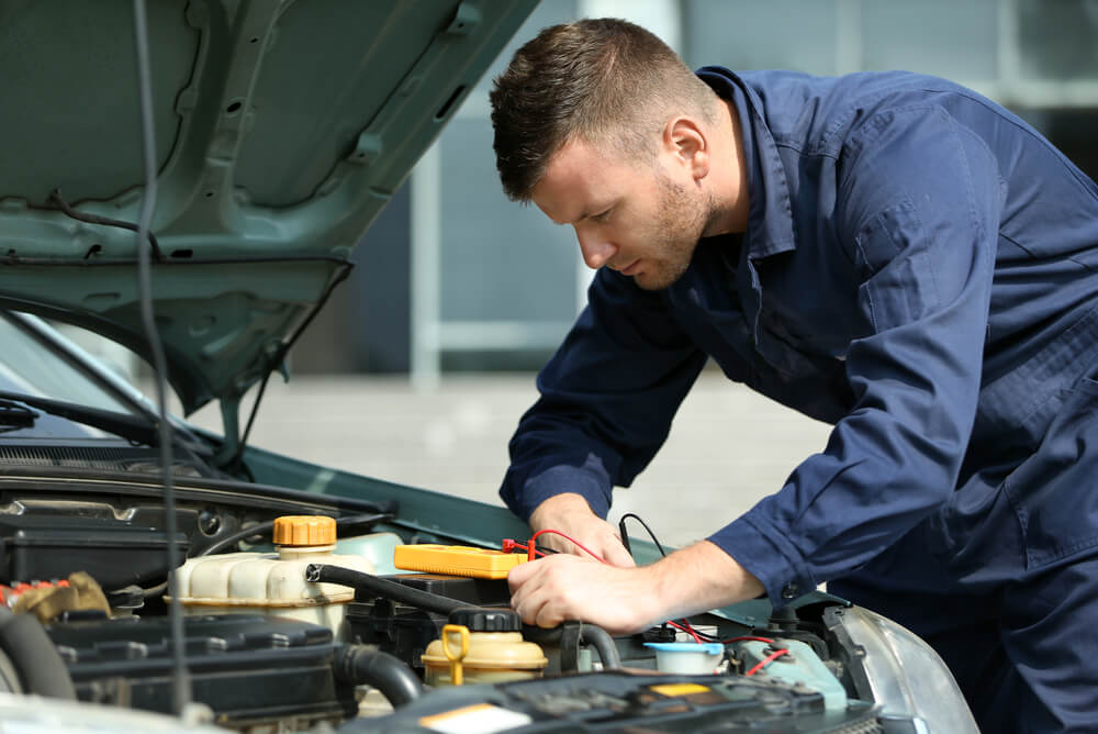A mechanic working on the engine of a car.