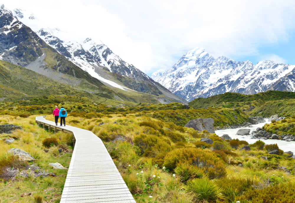 two people in new zealand with travel insurance walking through Aoraki Mount Cook National Park