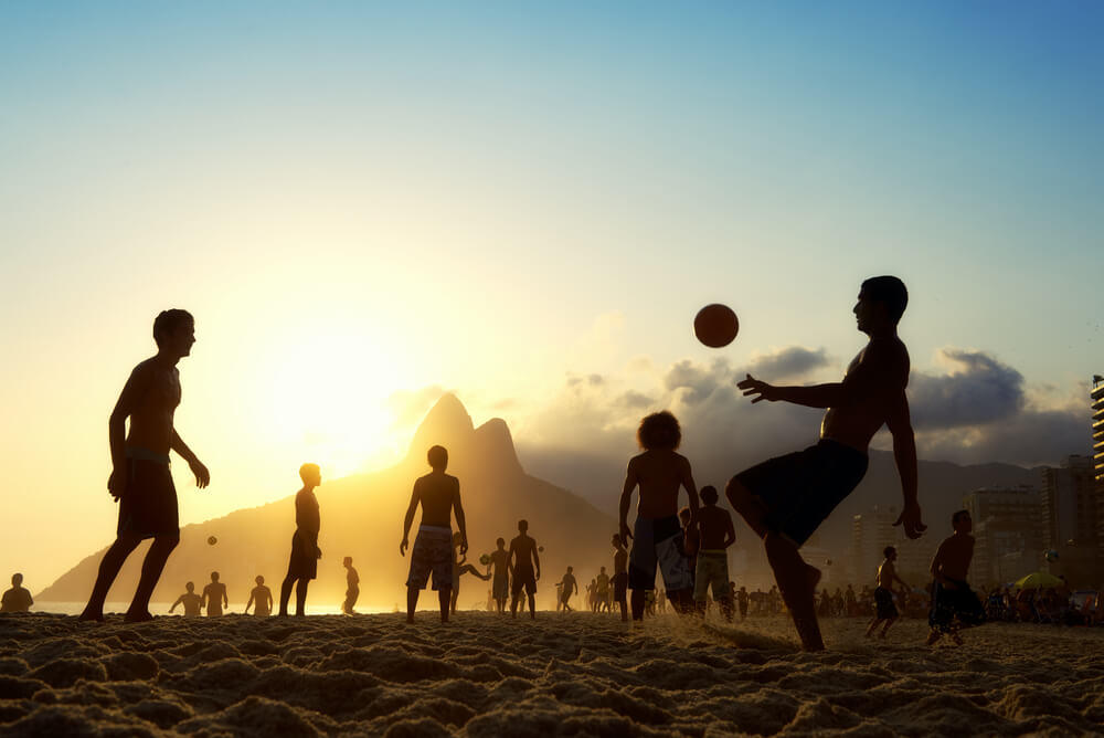 people playing football on the beach in Brazil