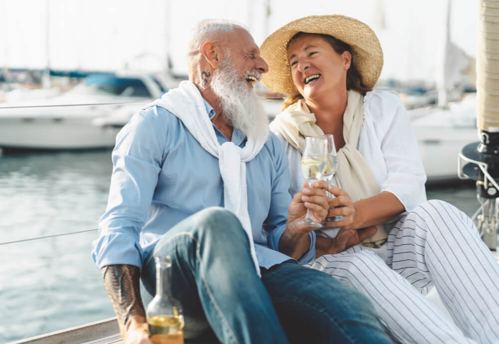 Over-65s with travel insurance drinking wine by the sea