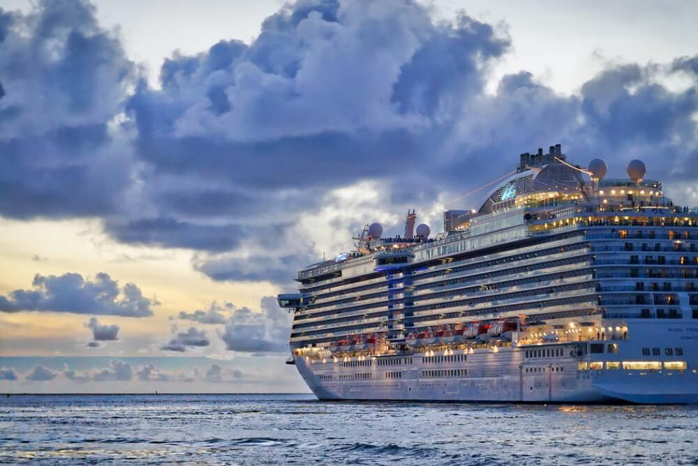 a cruise ship at dusk on the ocean