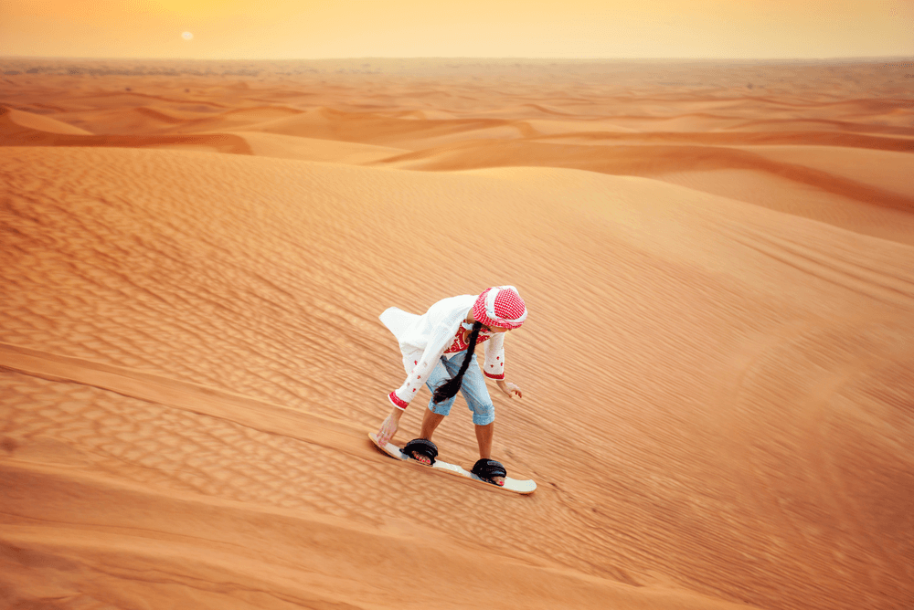 a tourist sand boarding in the desert in the UAE