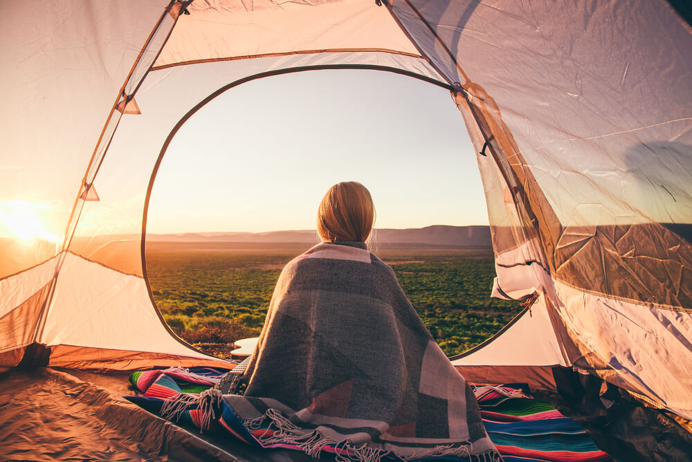 a woman sitting in her tent while camping in South Africa