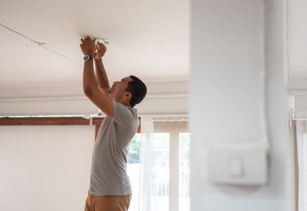 Man installing LED light at home