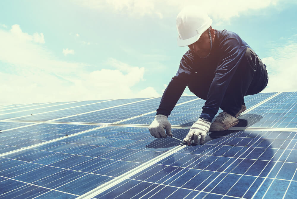 man installing solar panels on Australian home