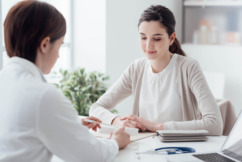 a woman who has health insurance with pre-existing conditions talking to doctor